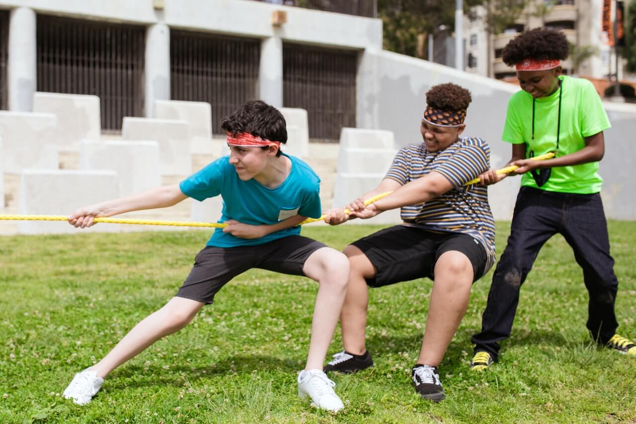 Kids playing tug of war as a summer camp game