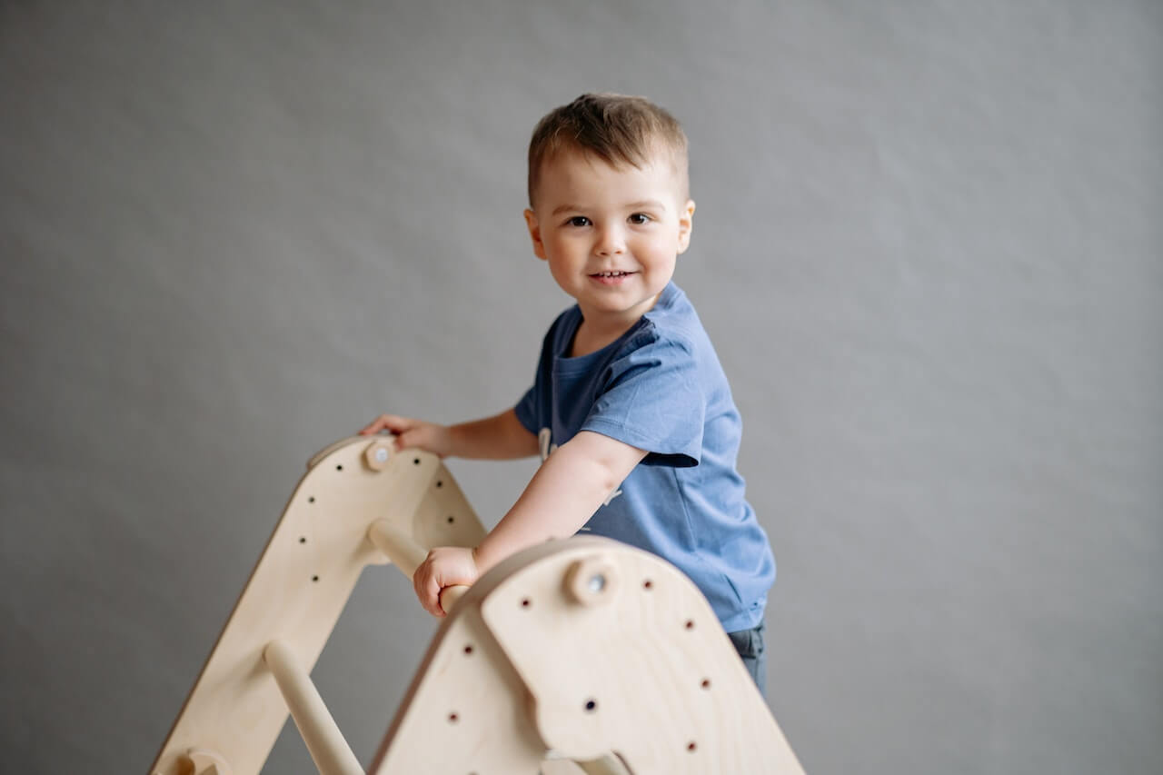 Boy climbing over triangle ladder