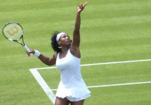 Female sports role model Serena Williams serves the tennis ball