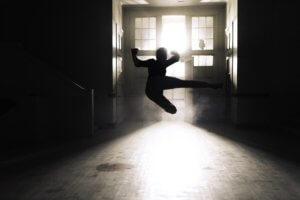 Martial arts practice in a studio lit by sunlight.