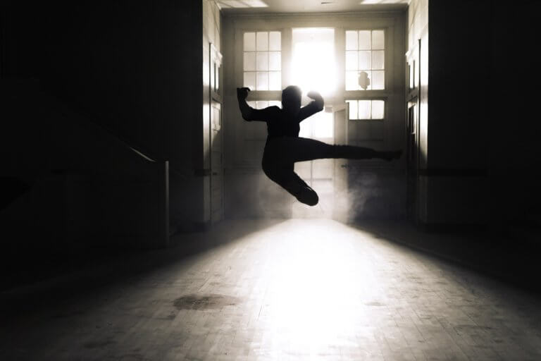 Martial arts practice in a studio lit by sunlight.