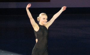 Woman at figure skating competition wearing black figure skates.