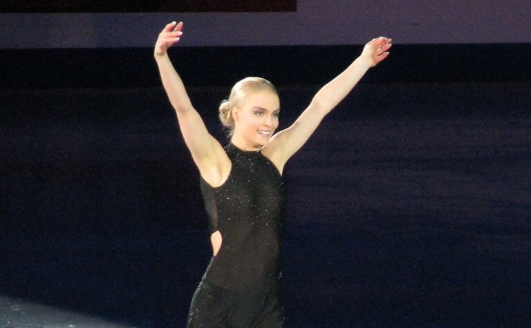 Woman at figure skating competition wearing black figure skates.