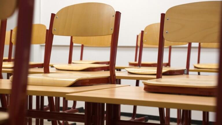 Empty chairs in a classroom representing the transition to virtual classes