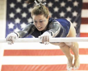 Difficult gymnastics skills on uneven bars performed by women's gymnast.