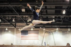 Woman in sport, competing in gymnastics on the balance beam.