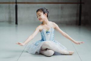 Dancer inspired by dance quotes, sitting on the studio floor