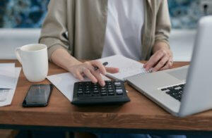 Woman calculating her auto-renew fees on her calculater