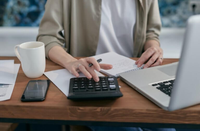 Woman calculating her auto-renew fees on her calculater