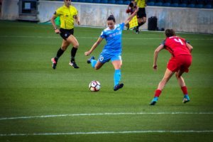 Soccer player kicking the ball outside the 18 yard box